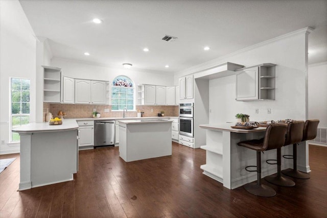 1109 Sherrill Ln, Lexington, TX 78947 - kitchen featuring open shelves, appliances with stainless steel finishes, a peninsula, a center island, and tasteful backsplash