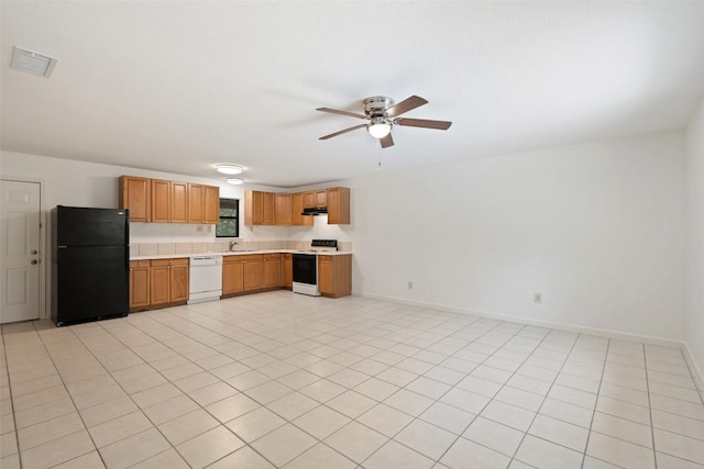 111 Sendero Blvd, Cedar Creek, TX 78612 - kitchen featuring white appliances, light countertops, a ceiling fan, under cabinet range hood, and brown cabinets