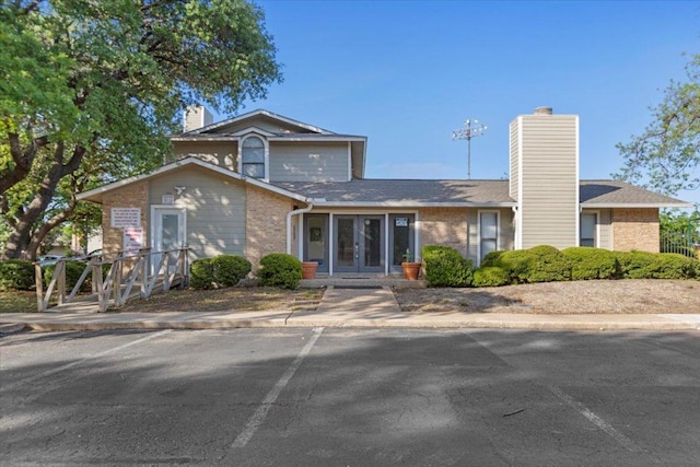 10616 Mellow Meadows Dr Unit 21C, Austin, TX 78750 - view of front of home with french doors, brick siding, and a chimney