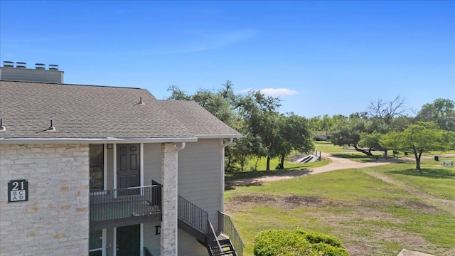10616 Mellow Meadows Dr Unit 21C, Austin, TX 78750 - view of side of home with roof with shingles, a lawn, and stone siding