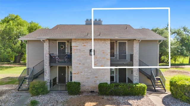 10616 Mellow Meadows Dr Unit 21C, Austin, TX 78750 - back of property featuring stairs, a chimney, stone siding, and roof with shingles