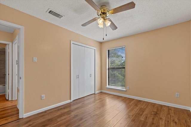 10616 Mellow Meadows Dr Unit 21C, Austin, TX 78750 - unfurnished bedroom featuring wood finished floors, a closet, ceiling fan, and a textured ceiling