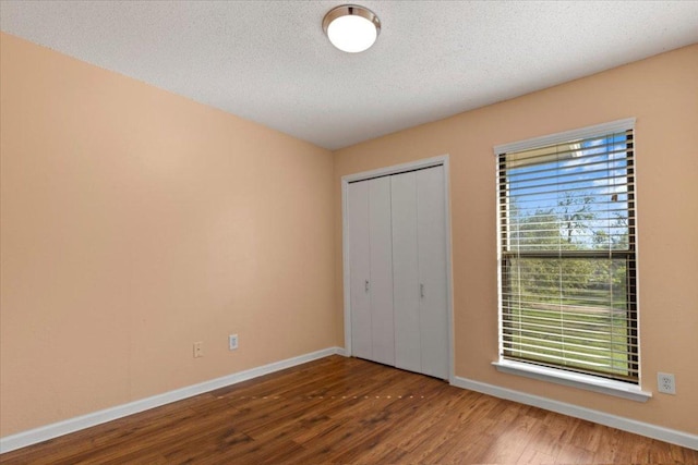 10616 Mellow Meadows Dr Unit 21C, Austin, TX 78750 - unfurnished bedroom featuring wood finished floors, a closet, and a textured ceiling