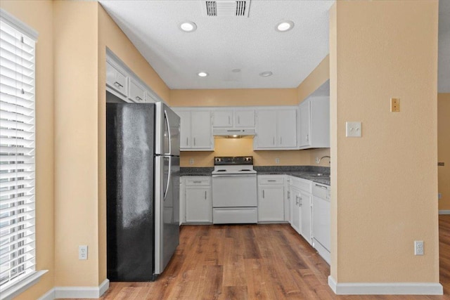10616 Mellow Meadows Dr Unit 21C, Austin, TX 78750 - kitchen with white appliances, under cabinet range hood, dark wood finished floors, healthy amount of natural light, and recessed lighting