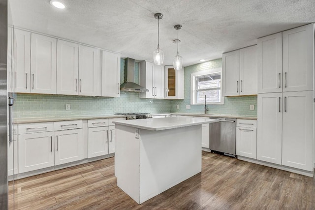 908 Hollybluff St, Austin, TX 78753 - kitchen featuring dishwasher, wall chimney range hood, light wood finished floors, light countertops, and a textured ceiling