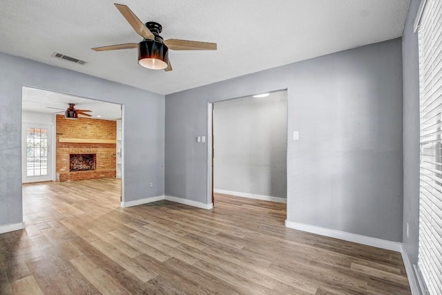 908 Hollybluff St, Austin, TX 78753 - unfurnished living room featuring ceiling fan, wood finished floors, and a fireplace