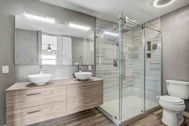 908 Hollybluff St, Austin, TX 78753 - full bath featuring a textured wall, a shower stall, double vanity, wood finished floors, and ceiling fan