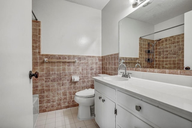 908 Hollybluff St, Austin, TX 78753 - full bath featuring tile walls, tile patterned flooring, vanity, a wainscoted wall, and a textured ceiling