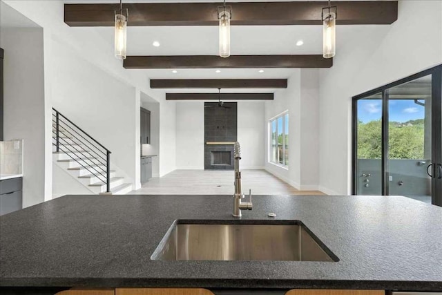 512 Cowal Dr S, Spicewood, TX 78669 - kitchen featuring beamed ceiling, a fireplace, open floor plan, recessed lighting, and wood finished floors