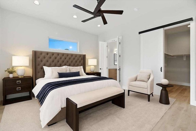 512 Cowal Dr S, Spicewood, TX 78669 - bedroom featuring light wood-style floors, recessed lighting, a ceiling fan, and a walk in closet