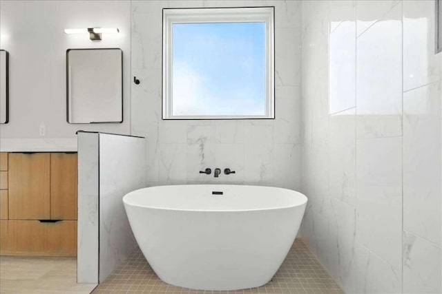512 Cowal Dr S, Spicewood, TX 78669 - bathroom with a soaking tub, vanity, and tile walls