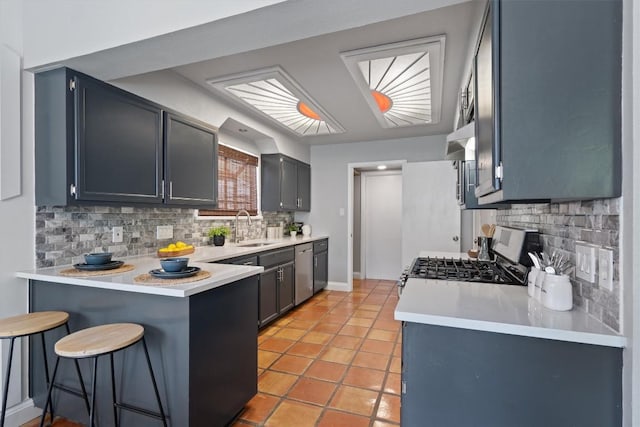 1707 Creek Bend Cir, Round Rock, TX 78681 - kitchen with appliances with stainless steel finishes, a peninsula, decorative backsplash, a kitchen breakfast bar, and light countertops
