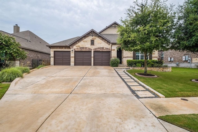 6708 Leonardo Dr, Round Rock, TX 78665 - french provincial home with a front yard, driveway, an attached garage, and stone siding