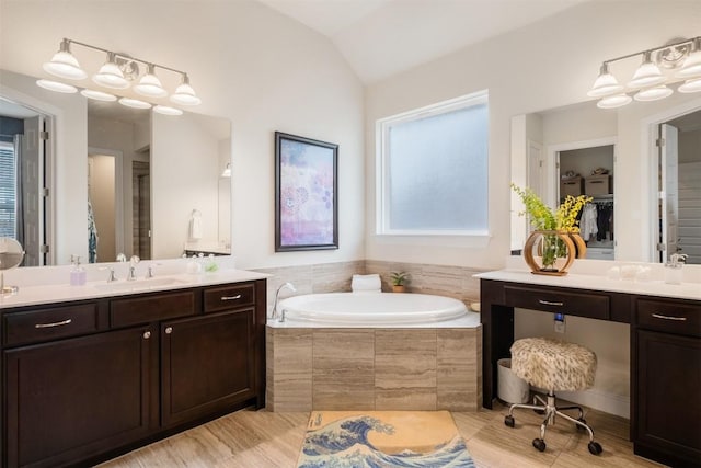 6708 Leonardo Dr, Round Rock, TX 78665 - bathroom featuring a garden tub, vanity, vaulted ceiling, and a spacious closet