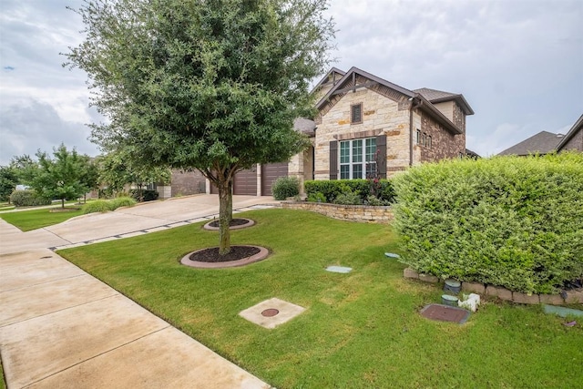 6708 Leonardo Dr, Round Rock, TX 78665 - view of front facade with stone siding, concrete driveway, a front lawn, and an attached garage