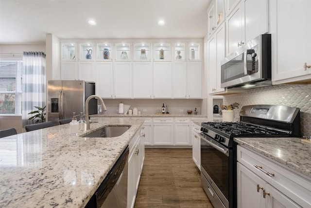 6708 Leonardo Dr, Round Rock, TX 78665 - kitchen featuring appliances with stainless steel finishes, white cabinets, wood finished floors, tasteful backsplash, and recessed lighting