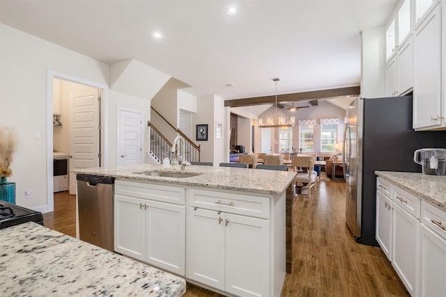 6708 Leonardo Dr, Round Rock, TX 78665 - kitchen featuring appliances with stainless steel finishes, white cabinets, dark wood-style floors, light stone countertops, and recessed lighting