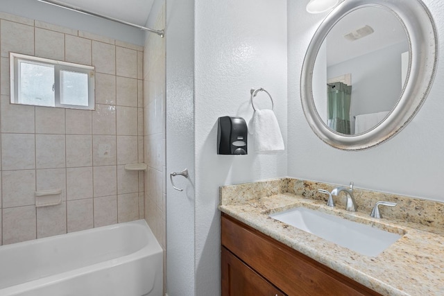5700 Jain Ln, Austin, TX 78721 - full bathroom featuring vanity, a textured wall, and shower / bath combo