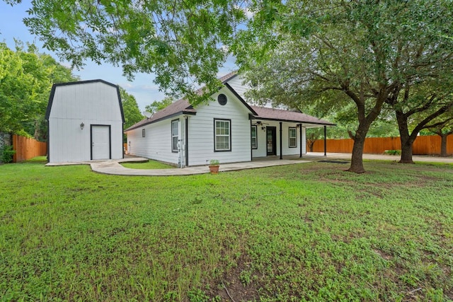 5700 Jain Ln, Austin, TX 78721 - back of property featuring ceiling fan, a storage shed, and a shingled roof