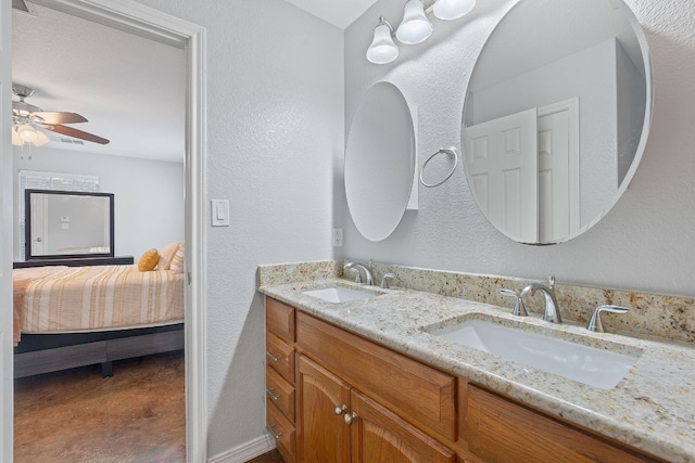 5700 Jain Ln, Austin, TX 78721 - bathroom featuring connected bathroom, double vanity, a ceiling fan, and a textured wall