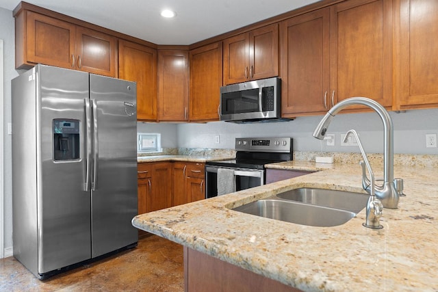 5700 Jain Ln, Austin, TX 78721 - kitchen with appliances with stainless steel finishes, brown cabinets, light stone counters, and recessed lighting
