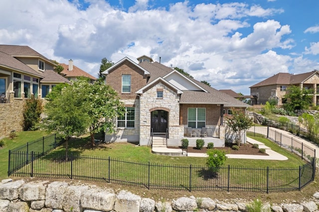 2304 Arroyo Grande, Leander, TX 78641 - view of front of house featuring stone siding, a fenced front yard, and brick siding