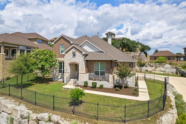 2304 Arroyo Grande, Leander, TX 78641 - view of front of house featuring stone siding, roof with shingles, and a fenced front yard