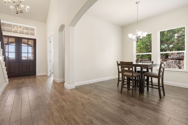2304 Arroyo Grande, Leander, TX 78641 - dining area with a chandelier, arched walkways, and dark wood-type flooring