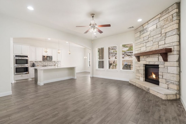 2304 Arroyo Grande, Leander, TX 78641 - unfurnished living room featuring a ceiling fan, a fireplace, dark wood finished floors, and recessed lighting