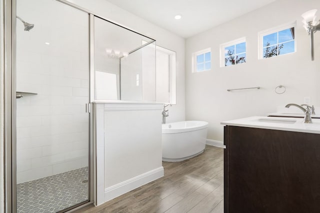 2304 Arroyo Grande, Leander, TX 78641 - bathroom with a shower stall, a soaking tub, vanity, and wood finished floors
