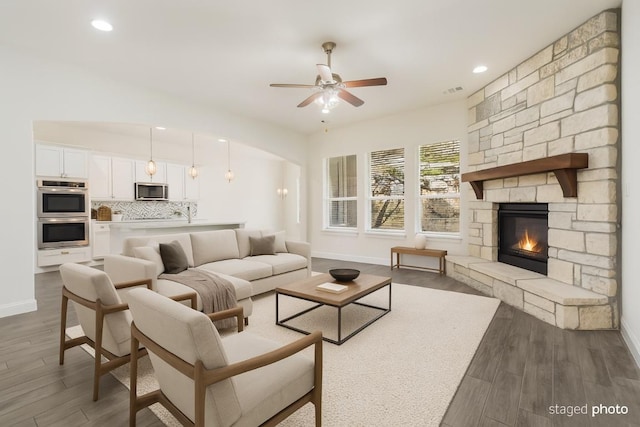 2304 Arroyo Grande, Leander, TX 78641 - living room with a ceiling fan, wood finished floors, a stone fireplace, and recessed lighting