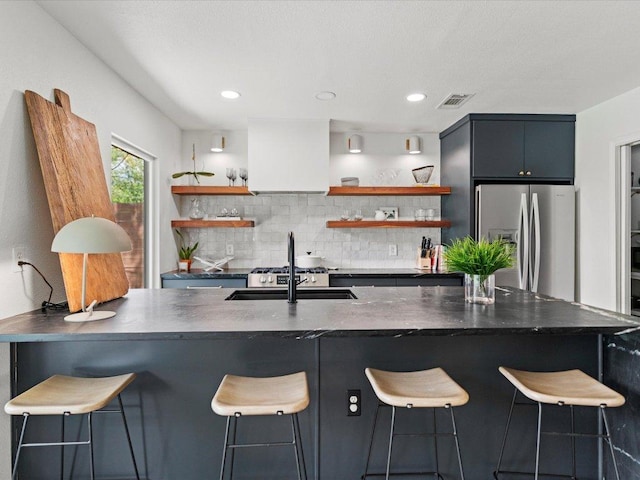 1907 Parkside Ln, Austin, TX 78745 - kitchen with stainless steel refrigerator with ice dispenser, open shelves, dark countertops, backsplash, and recessed lighting