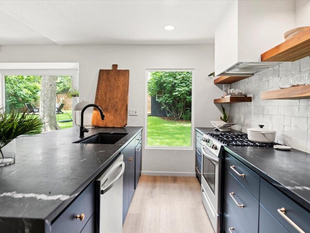 1907 Parkside Ln, Austin, TX 78745 - kitchen featuring open shelves, stainless steel appliances, decorative backsplash, light wood-style floors, and recessed lighting