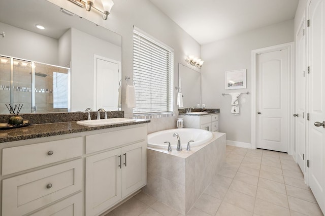1304 Positano Pass, Leander, TX 78641 - bathroom featuring a shower stall, two vanities, tile patterned floors, and a garden tub