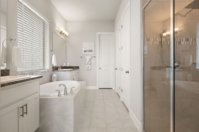 1304 Positano Pass, Leander, TX 78641 - full bathroom featuring two vanities, a stall shower, a bath, and tile patterned flooring