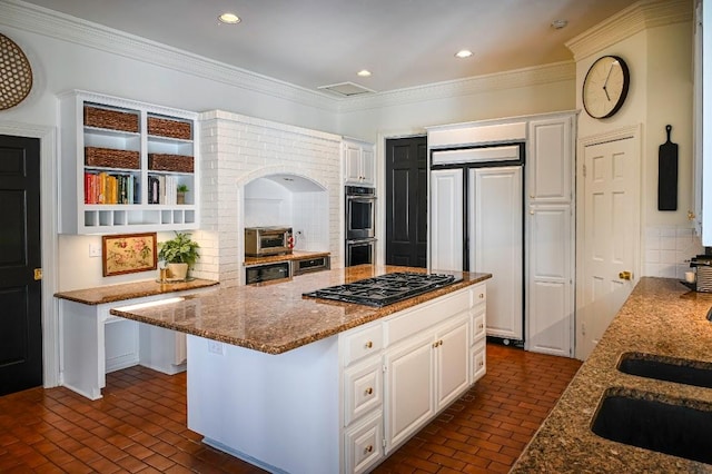 4119 Hidden Canyon Cv, Austin, TX 78746 - kitchen featuring paneled built in fridge, gas cooktop, brick floors, decorative backsplash, and crown molding