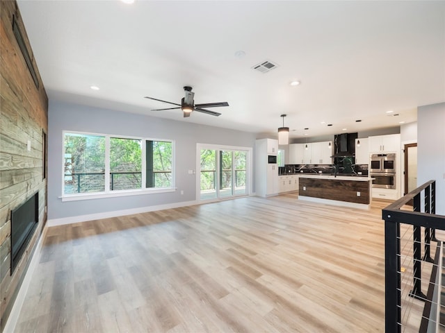 3013 Clark Ave, Lago Vista, TX 78645 - unfurnished living room with a stone fireplace, ceiling fan, recessed lighting, and light wood-style floors