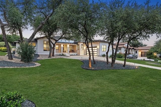 209 Ringtail Stream Dr, Lakeway, TX 78738 - view of front of house featuring stucco siding, an attached garage, concrete driveway, a front lawn, and covered porch