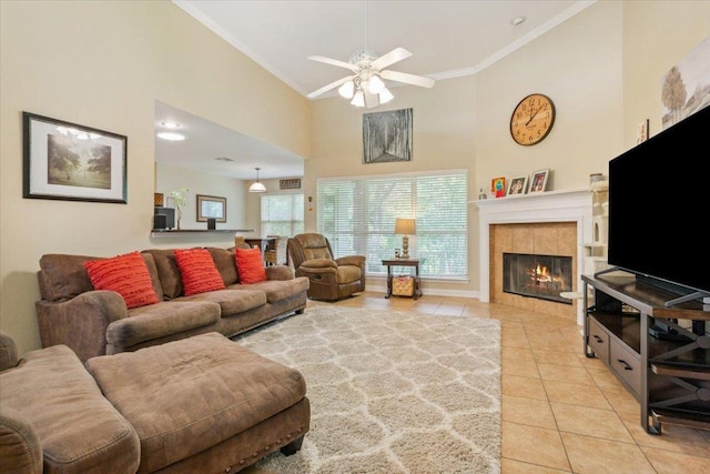 2802 Amber Forest Trl, Belton, TX 76513 - living area with light tile patterned floors, crown molding, high vaulted ceiling, ceiling fan, and a tiled fireplace