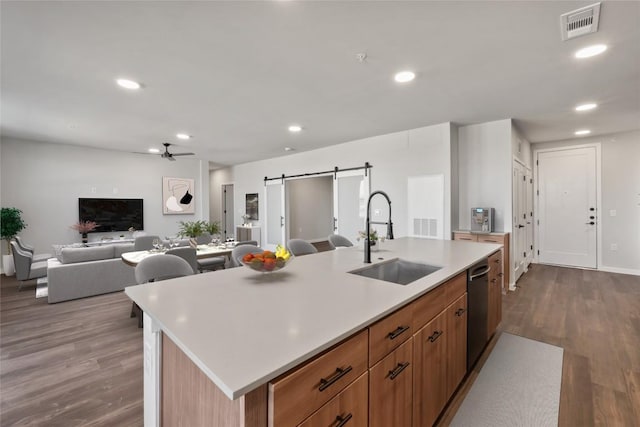4510 Terry-O Ln Unit 322, Austin, TX 78745 - kitchen featuring a ceiling fan, dark wood-style flooring, a barn door, light countertops, and a center island with sink