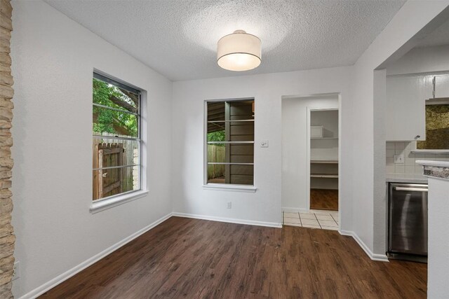 2616 Audubon Pl, Austin, TX 78741 - unfurnished dining area with dark wood-type flooring and a textured ceiling