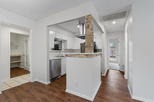 2616 Audubon Pl, Austin, TX 78741 - kitchen featuring dishwasher, white cabinets, light countertops, dark wood-style flooring, and a peninsula