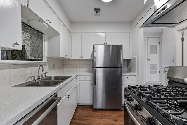2616 Audubon Pl, Austin, TX 78741 - kitchen with stainless steel appliances, exhaust hood, light countertops, and white cabinetry