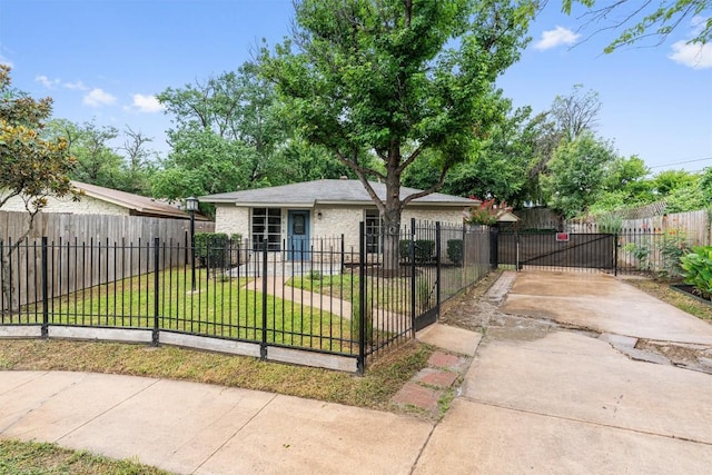2616 Audubon Pl, Austin, TX 78741 - view of front facade with concrete driveway, brick siding, a fenced front yard, and a gate