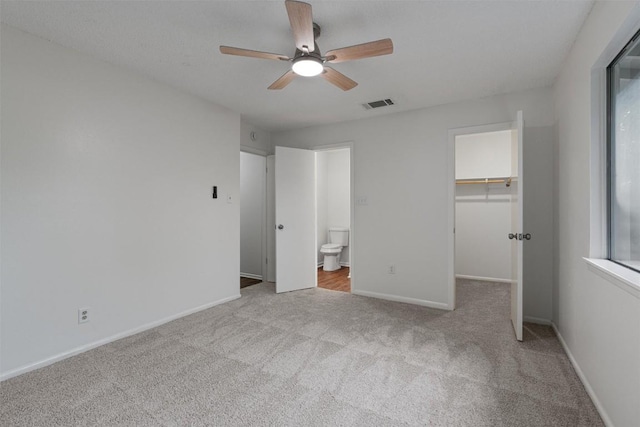 2616 Audubon Pl, Austin, TX 78741 - unfurnished bedroom featuring carpet flooring, a walk in closet, ensuite bath, and ceiling fan