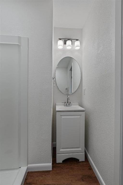 2616 Audubon Pl, Austin, TX 78741 - bathroom featuring wood finished floors, vanity, and a textured wall