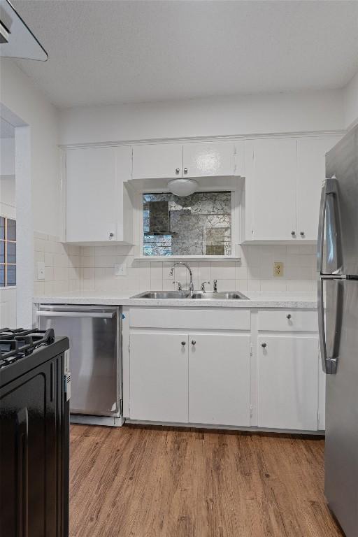 2616 Audubon Pl, Austin, TX 78741 - kitchen featuring stainless steel appliances, white cabinetry, and tasteful backsplash