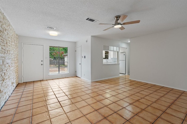2616 Audubon Pl, Austin, TX 78741 - unfurnished living room featuring ceiling fan, a textured ceiling, and tile patterned floors