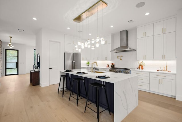 3005 French Pl, Austin, TX 78722 - kitchen featuring wall chimney exhaust hood, high end refrigerator, light wood-type flooring, a breakfast bar, and white cabinets