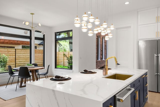 3005 French Pl, Austin, TX 78722 - kitchen with appliances with stainless steel finishes, light wood-style flooring, an island with sink, a chandelier, and recessed lighting